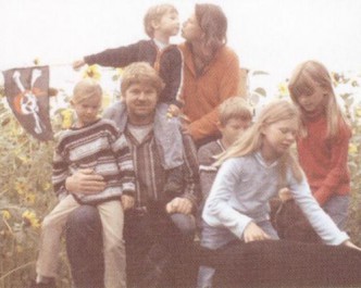 Matthias und Birte Stührwoldt und ihre Kinder Marie, Nora, Peer, Carla und Jon sitzen zusammen im Freien.
